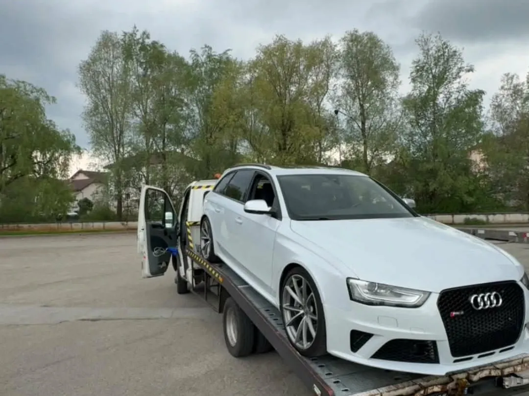 Voiture rachetée en l'état, sanglée sur le plateau avant départ vers le dépôt